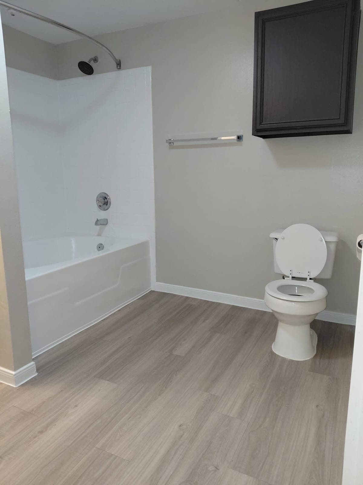 Bathroom with a clean tub, toilet and floor