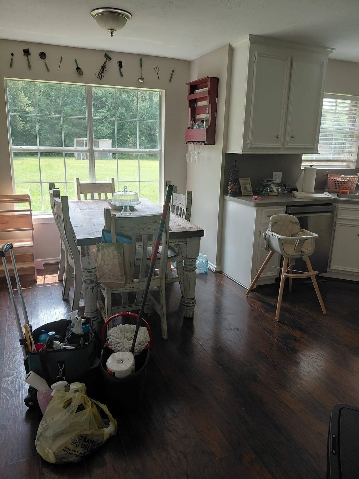 Kitchen before cleaning, with the cleaning supplies on the floor