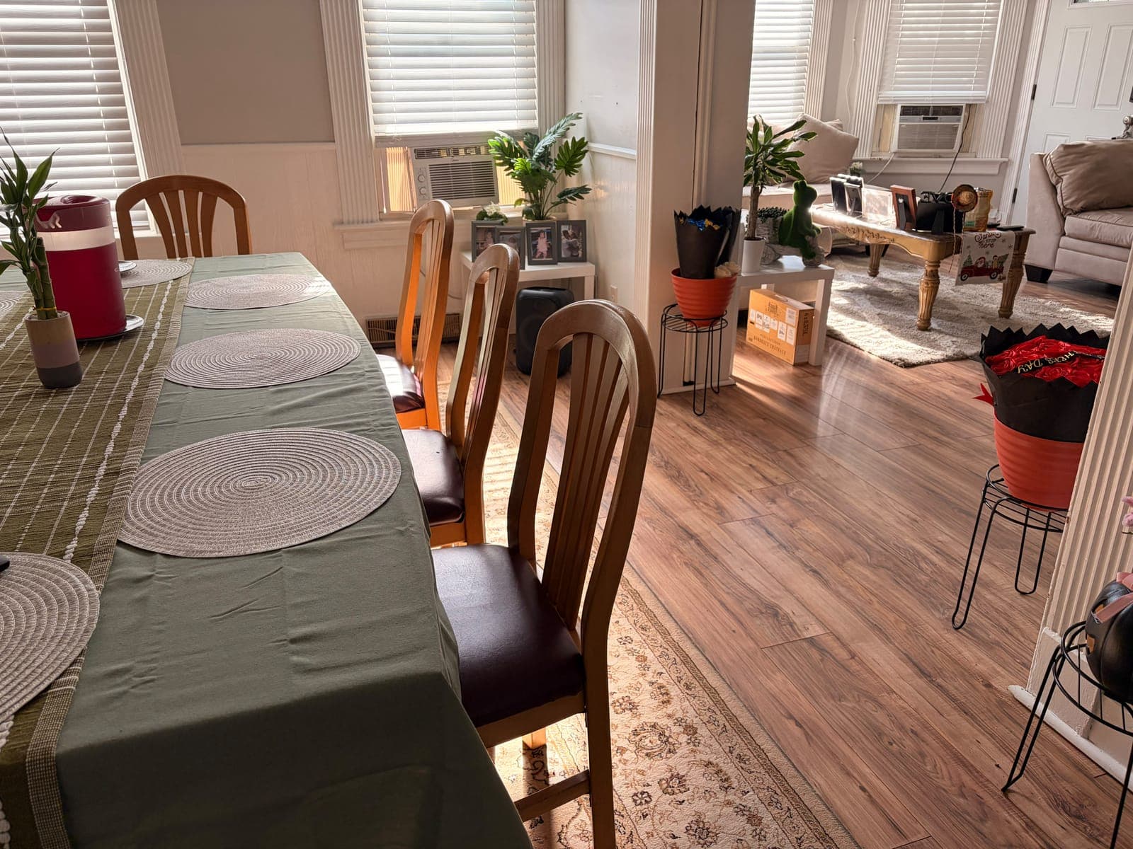 Dining room with the table set and the living room behind it, all clean