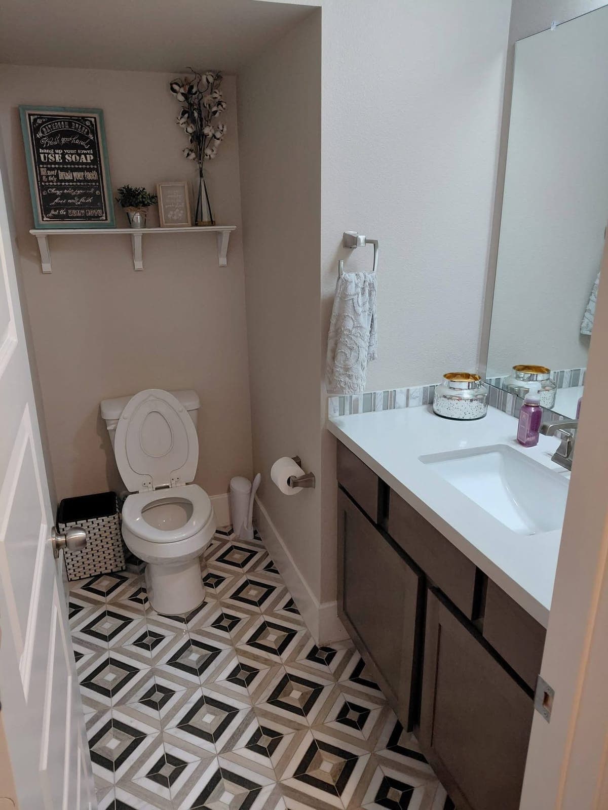 Half bathroom with a clean mosaic floor and sink